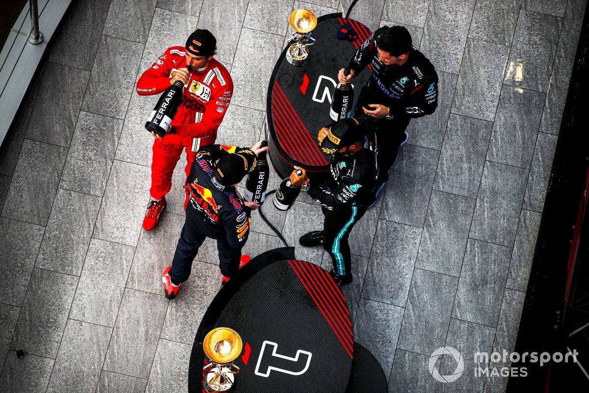 Max Verstappen, Red Bull Racing, 2a posizione, Carlos Sainz Jr., Ferrari, 3a posizione, il rappresentante del team Mercedes e Lewis Hamilton, Mercedes, 1a posizione, con Champagne sul podio