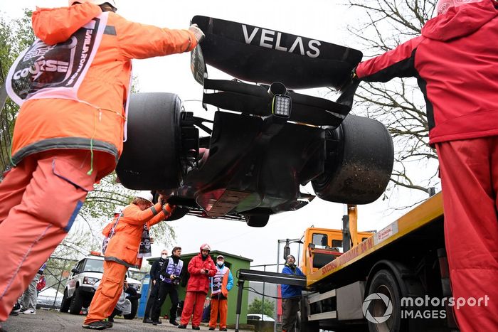 Oficiales de pista cargan el coche de Carlos Sainz Jr., Ferrari F1-75, en una grúa