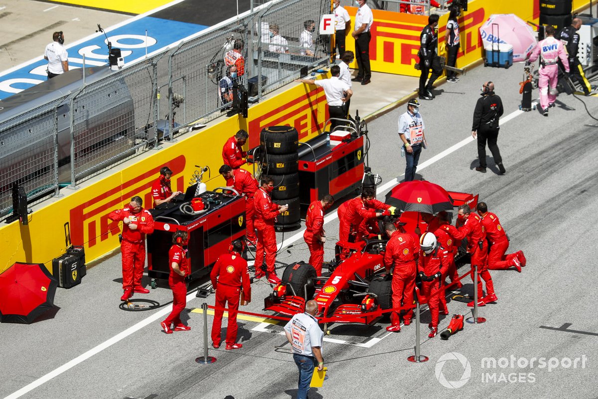 Meccanici e ingegneri Ferrari preparano l'auto di Sebastian Vettel, Ferrari SF1000, sulla griglia di partenza