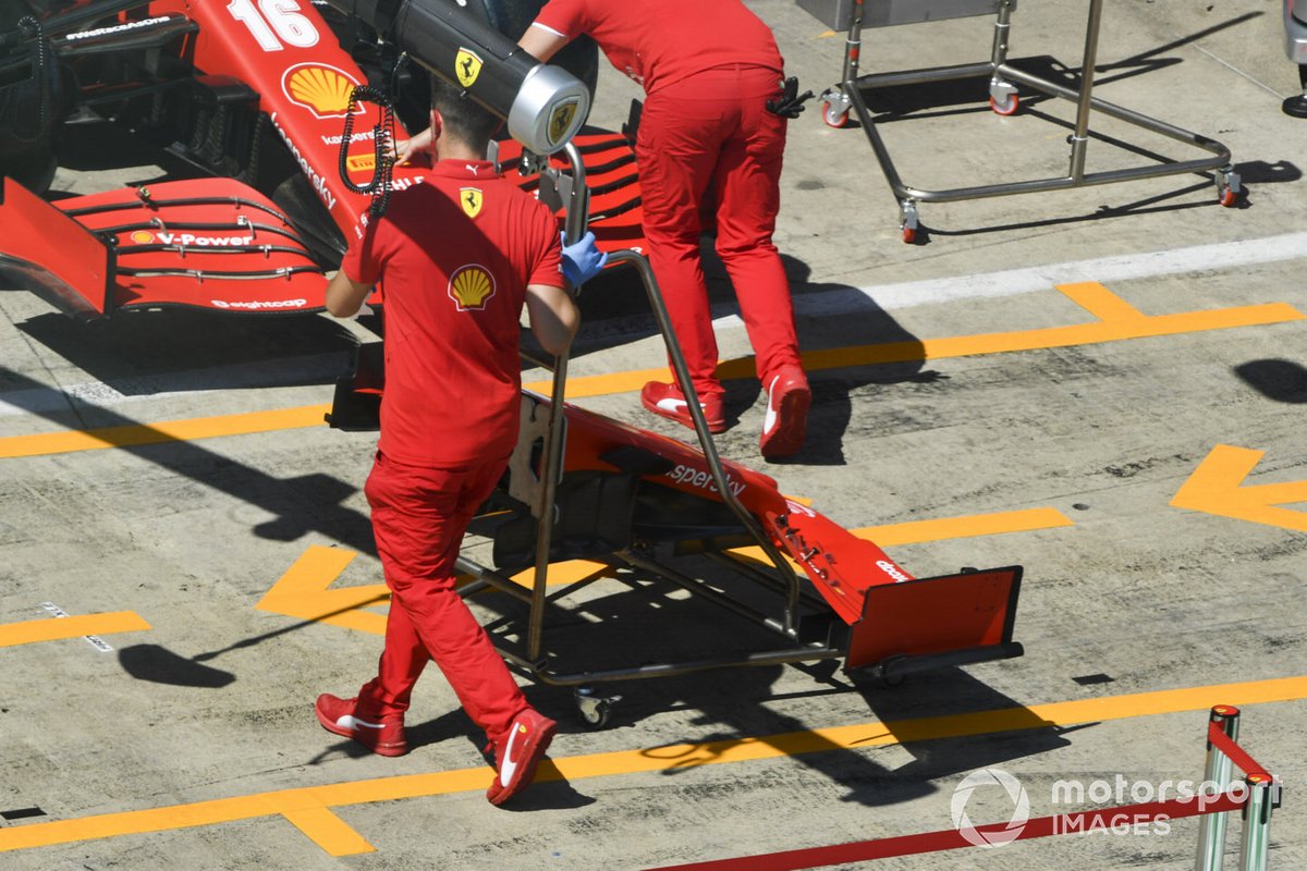 Ferrari mechanics push the car of Charles Leclerc, Ferrari SF1000 in the pit lane