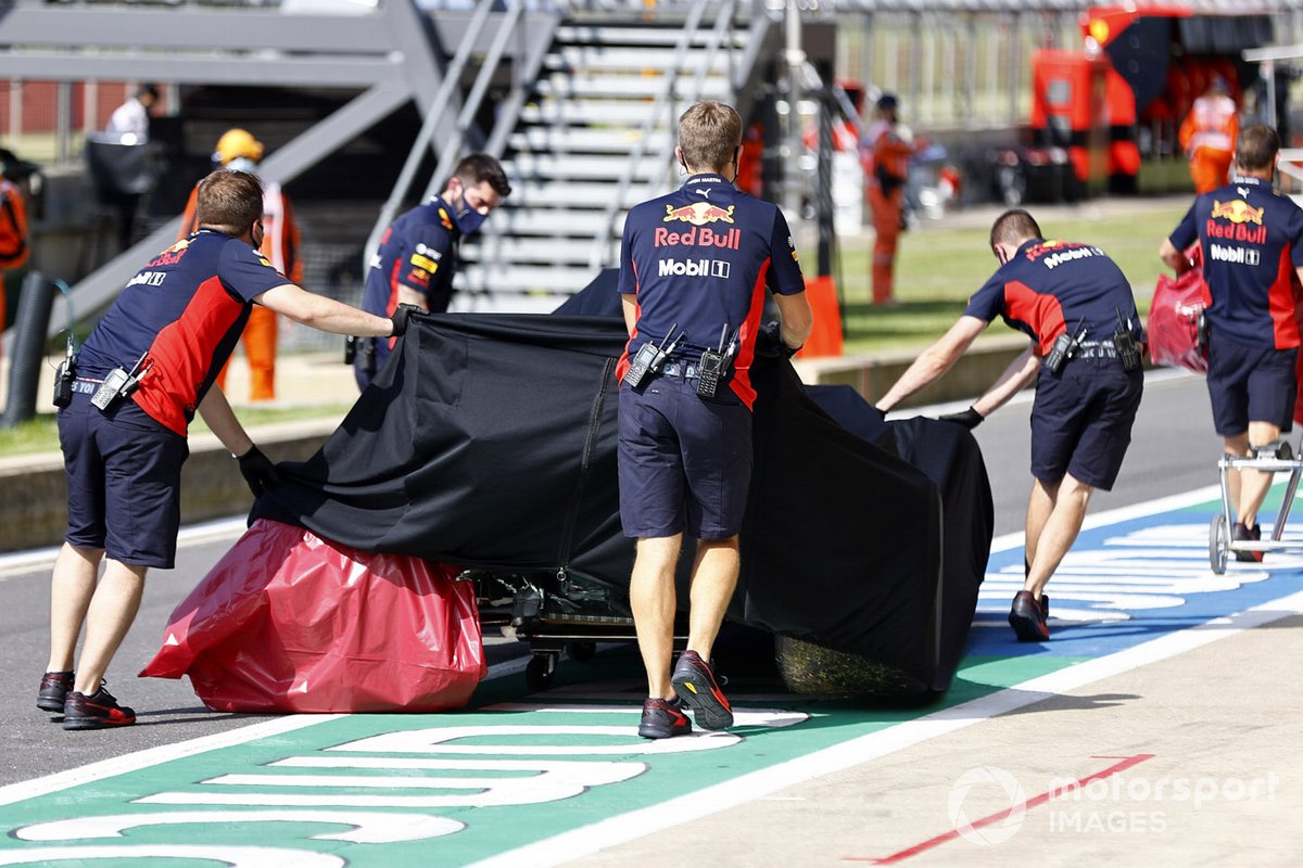 Los mecánicos de Red Bull con el monoplaza dañado de Alex Albon, Red Bull Racing RB16 en el garaje bajo una lona después de su accidente en la FP2