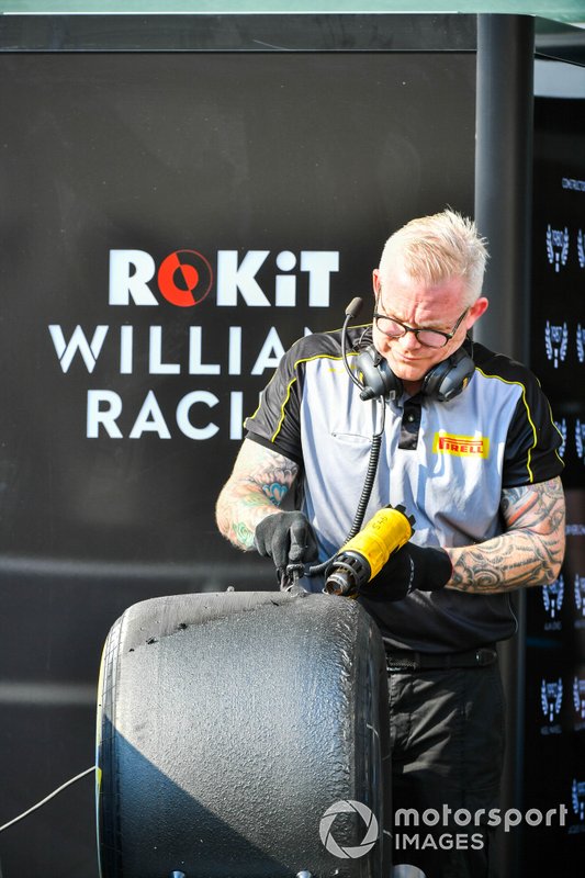 Pirelli team member cleans tyres 