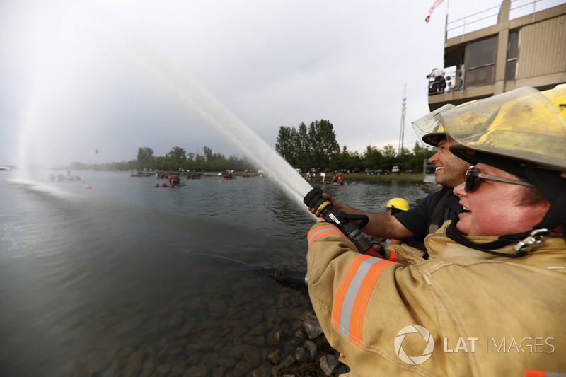Пожарные поливают водой участников гонки на плотах