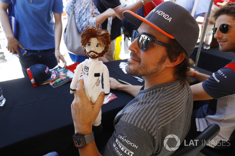 Fernando Alonso, McLaren, hält eine Puppe