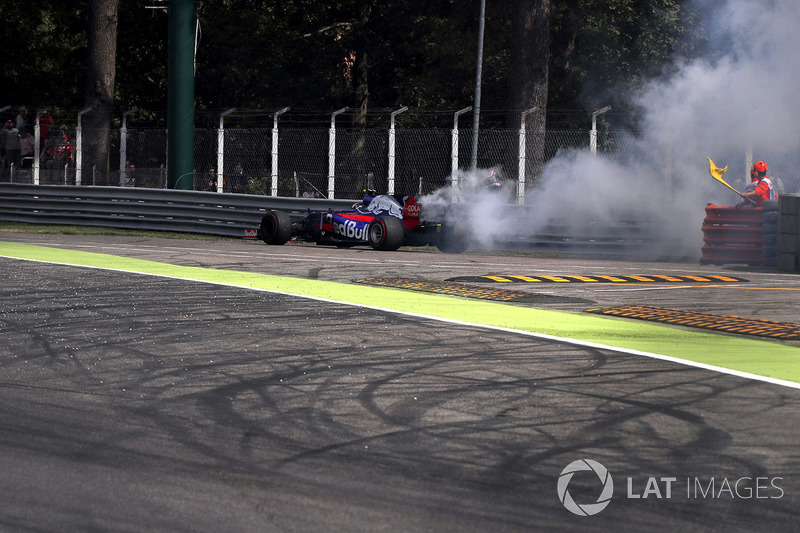 Marshal waves the yellow flag as Carlos Sainz Jr., Scuderia Toro Rosso STR12 stops on track