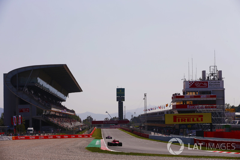 A Ferrari follows a Force India onto the pit straight