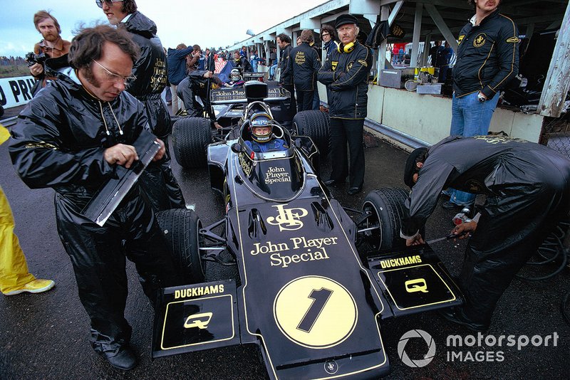 Ronnie Peterson waits in his Lotus 72E Ford, overseen by Colin Chapman