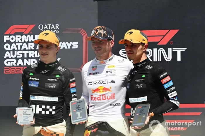 O vencedor do Sprint, Max Verstappen, da Red Bull Racing, segura o seu troféu entre Oscar Piastri, da McLaren F1 Team, e Lando Norris, da McLaren F1 Team 