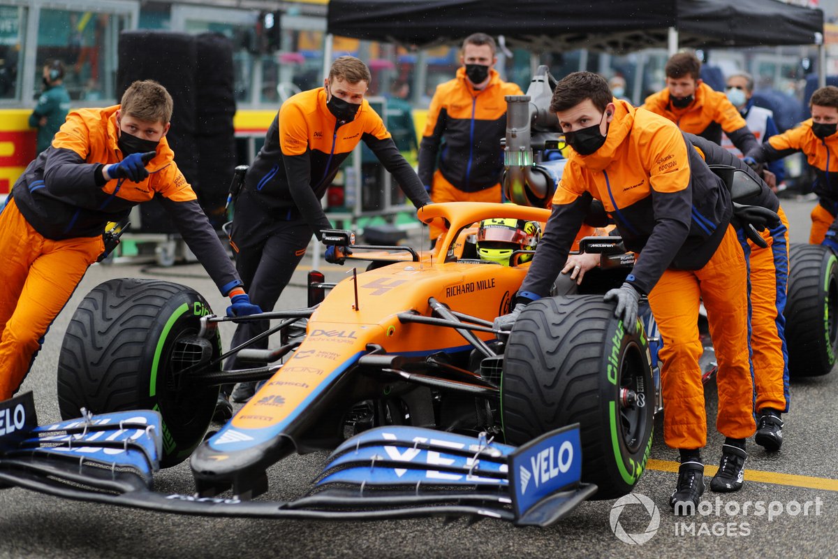 Los mecánicos empujan el coche de Lando Norris, McLaren MCL35M, en la parrilla de salida