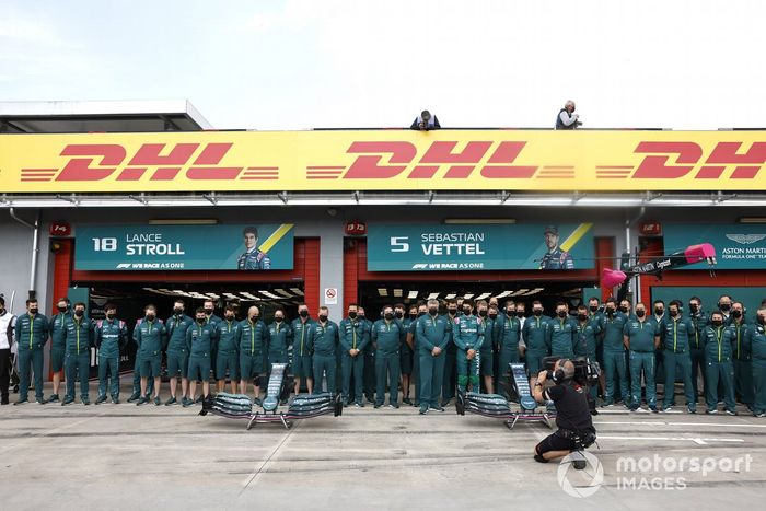 El equipo Aston Martin se pone de pie para una foto de equipo en el pit lane