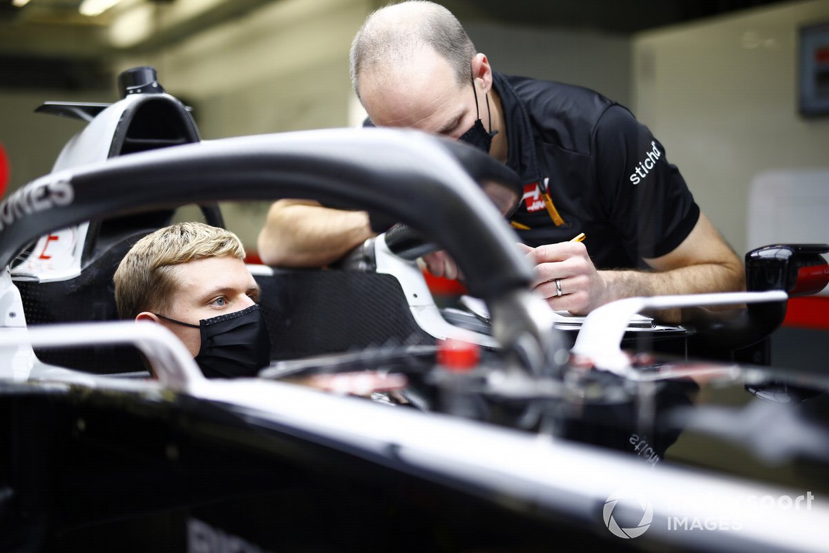 Mick Schumacher sits in his Haas VF-20 for his seat fitting with race engineer Gary Gannon