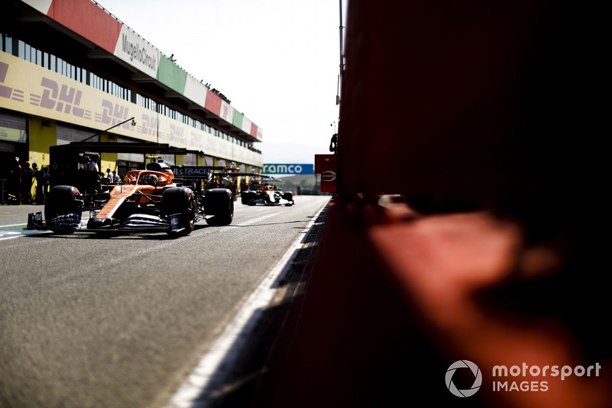 Lando Norris, McLaren MCL35, Carlos Sainz Jr., McLaren MCL35, in pit lane