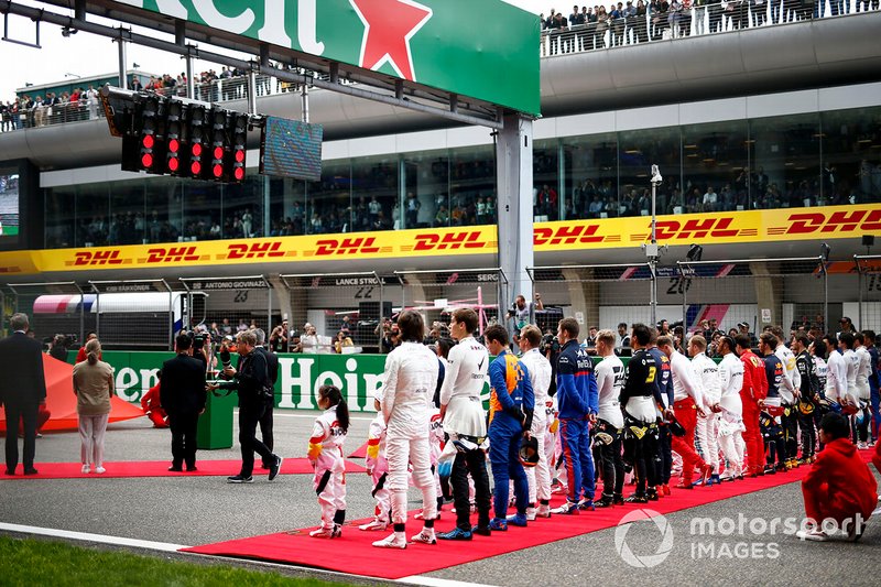 Drivers line up for the National Anthem on the grid
