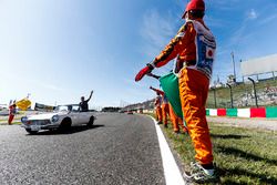 Marshals langs de baan wanneer Stoffel Vandoorne, McLaren, passeert tijdens de rijdersparade