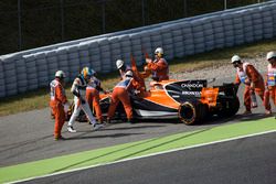 Les commissaires aident Fernando Alonso, McLaren MCL32, après qu'il ait dû garer sa voiture avec une casse moteur