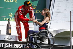 Third place Kimi Raikkonen, Ferrari, receives his trophy from Nathalie McGoin on the podium