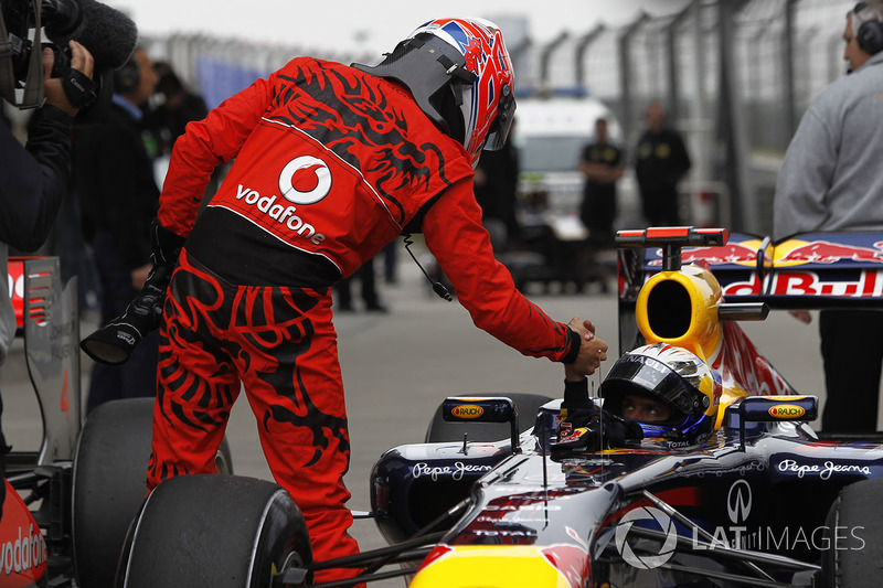 Jenson Button, McLaren, congratulates Sebastian Vettel, Red Bull Racing RB7 Renault, on pole in Parc Ferme