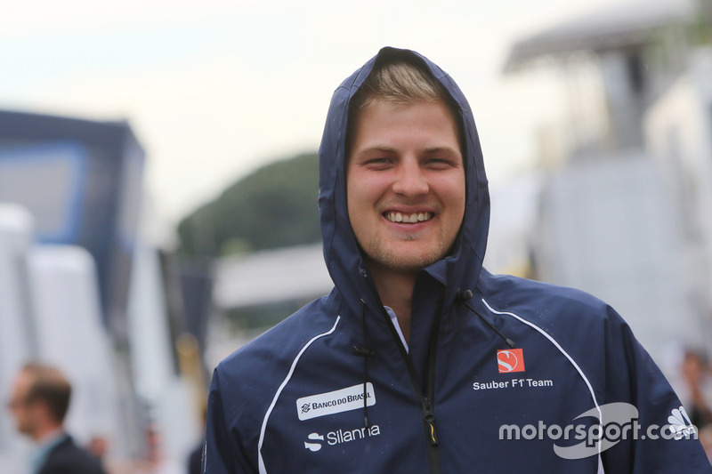 O sorridente, Marcus Ericsson, caminha pelo paddock