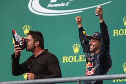 L'acteur Gerard Butler fait un shoey sur le podium avec Daniel Ricciardo, Red Bull Racing, troisième