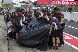 The crashed car of Romain Grosjean, Haas F1 Team VF-17 is returned to the pits
