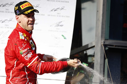 Sebastian Vettel, Ferrari, sprays the champagne on the podium after winning the race