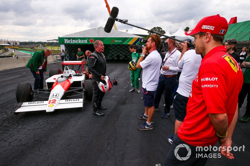 Sebastian Vettel, Ferrari looking at the McLaren MP4/4 whilst Martin Brundle, Sky TV speaks to the media