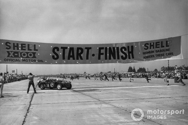 Drivers run to their cars at the start of the race