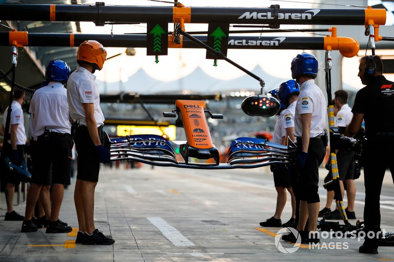 Los mecánicos sostienen la nariz y el alerón delantero, a la esperan a que Carlos Sainz Jr, McLaren MCL34, haga una parada en boxes