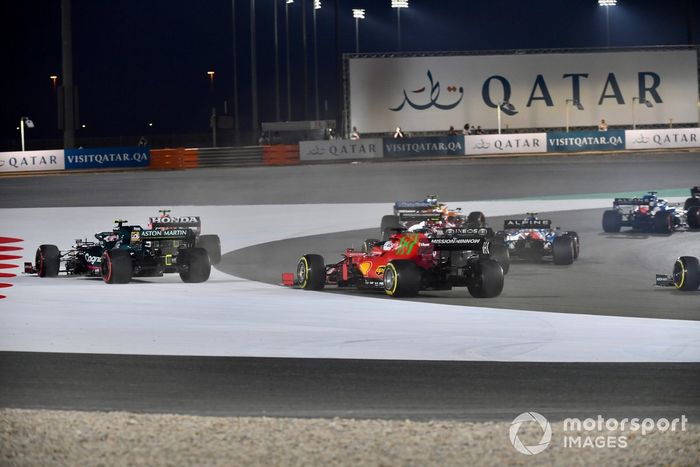Sergio Pérez, Red Bull Racing RB16B, y Sebastian Vettel, Aston Martin AMR21, se van por fuera por delante de Charles Leclerc, Ferrari SF21