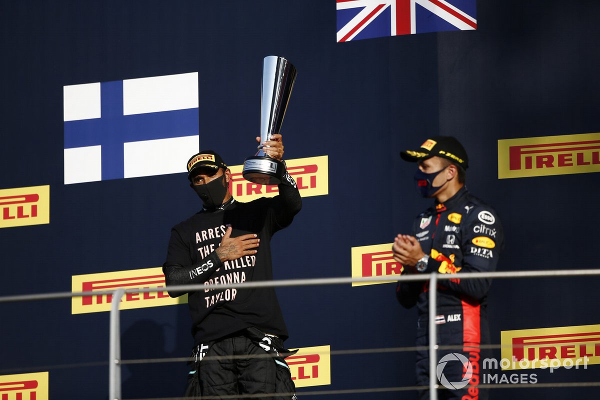 Lewis Hamilton, Mercedes-AMG F1, 1st position, with his trophy, and Alex Albon, Red Bull Racing, 3rd position, on the podium