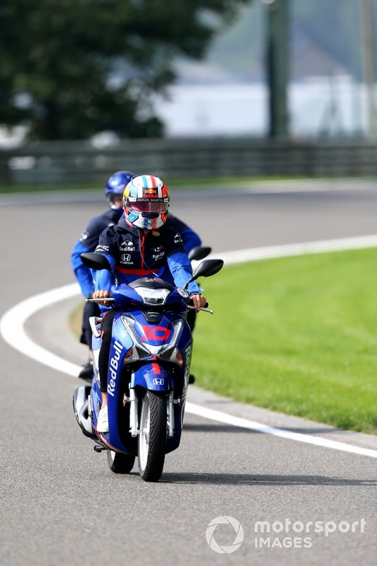 Pierre Gasly, Toro Rosso STR14, rides a scooter