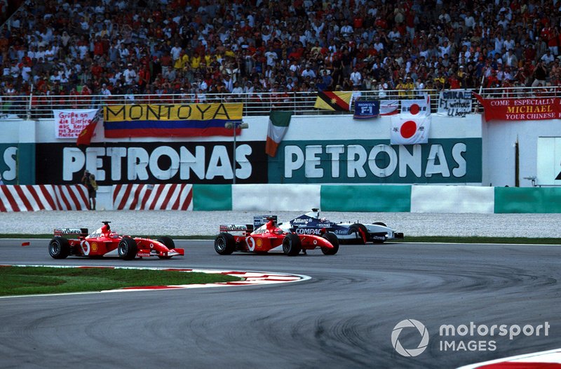 Rubens Barrichello, Ferrari F2001 prend la tête alors que Juan Pablo Montoya, Williams FW24 est au large après un contact avec Michael Schumacher, Ferrari F2001 au premier virage