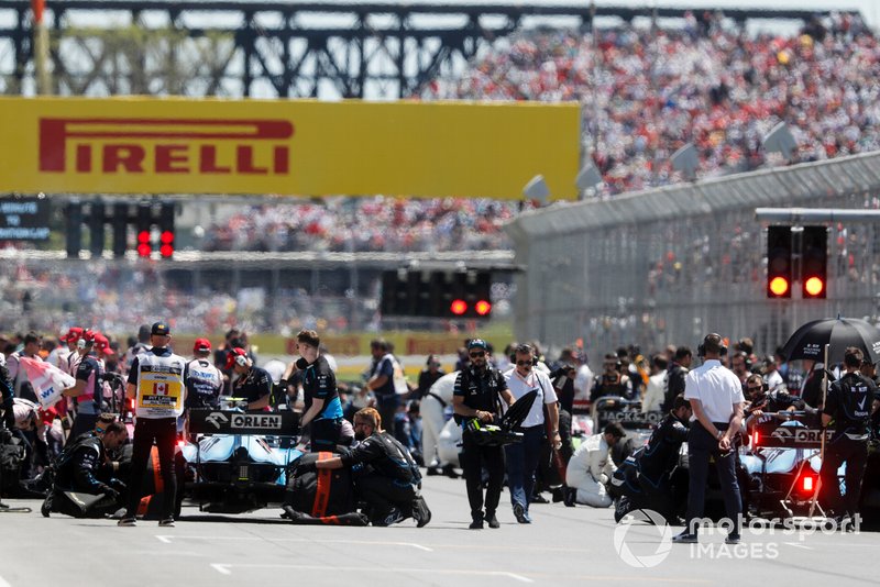 Mechanics clear the grid prior to the start of the formation lap
