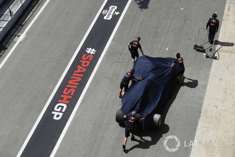Механики Red Bull Racing катят поврежденный автомобиль RB14 Даниэля Риккардо в гараж