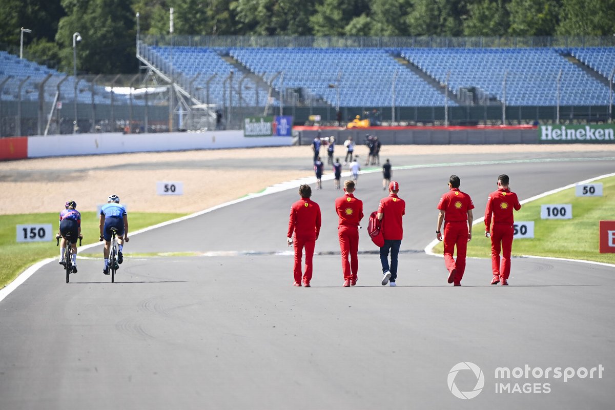 Valtteri Bottas, Mercedes-AMG Petronas F1 et Tiffany Cromwell font du vélo sur la piste en passant Sebastian Vettel, Ferrari pendant qu'il marche sur la piste avec ses ingénieurs