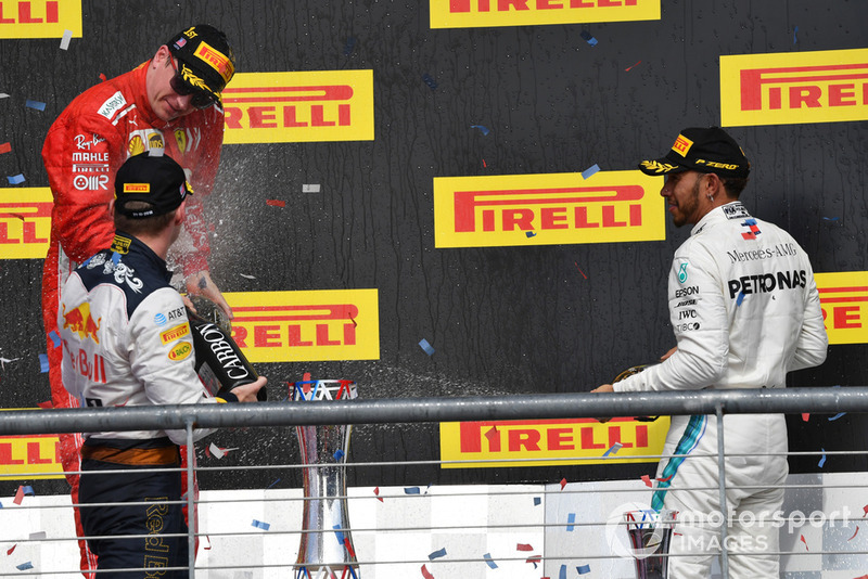 (L to R): Kimi Raikkonen, Ferrari, Max Verstappen, Red Bull Racing and Lewis Hamilton, Mercedes AMG F1 celebrate with the champagne on the podium with the trophy 