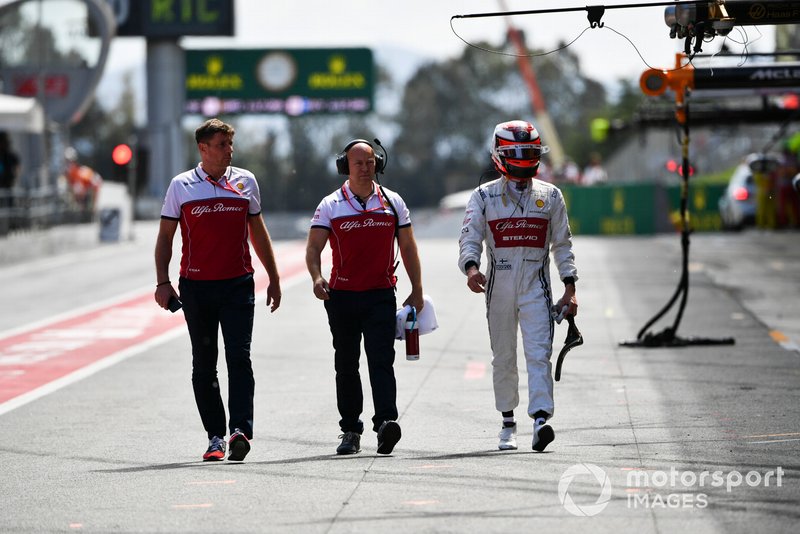 Kimi Raikkonen, Alfa Romeo Racing walks down the pit lane with Mark Arnall