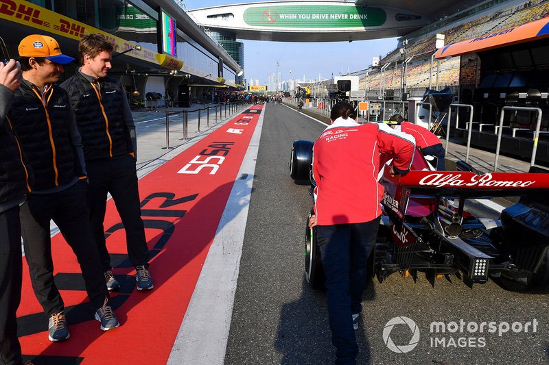 Carlos Sainz Jr., McLaren, observa el Alfa Romeo Racing C38