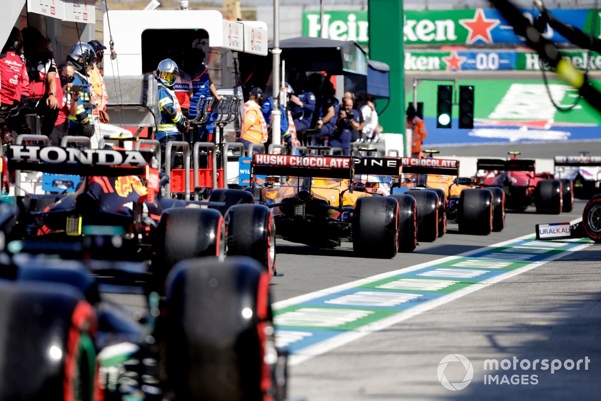 Daniel Ricciardo, McLaren MCL35M, y Sergio Pérez, Red Bull Racing RB16B, fila del pit lane
