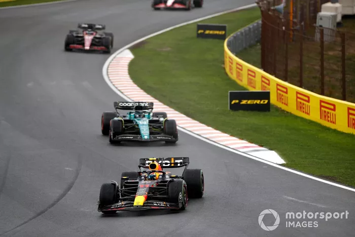 Sergio Pérez, Red Bull Racing RB19, por delante de Lance Stroll, Aston Martin AMR23, y Valtteri Bottas, Alfa Romeo C43.