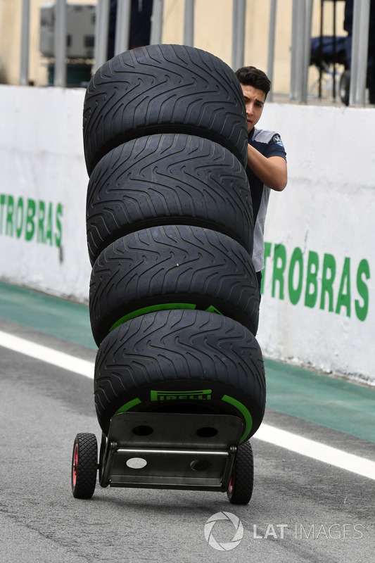 Un meccanico della Scuderia Toro Rosso con degli pneumatici Pirelli