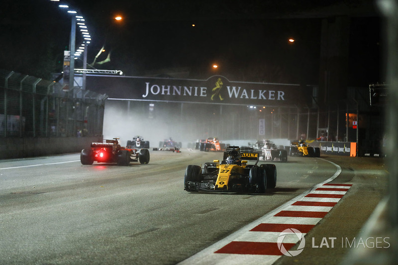 Nico Hulkenberg, Renault Sport F1 Team RS17, passes the damaged car of Sebastian Vettel, Ferrari SF70H