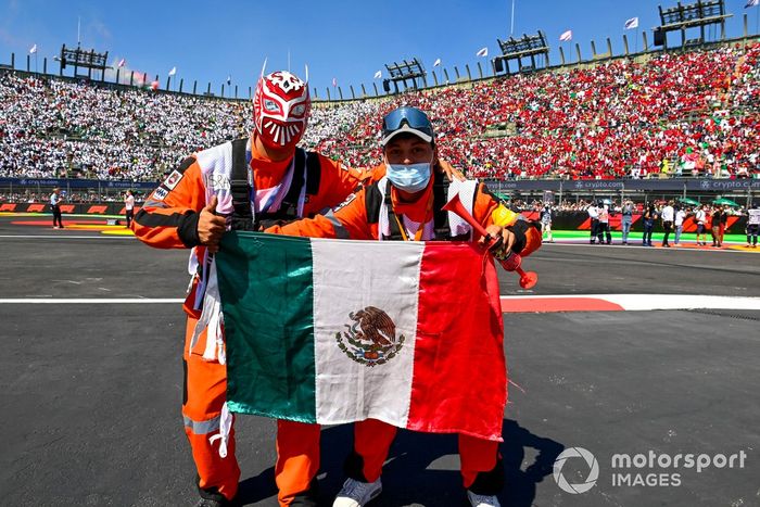 Oficiales de pista con la bandera de México