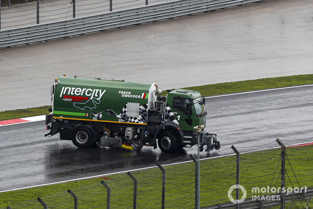 Un barredor de pista intenta limpiar el agua del circuito