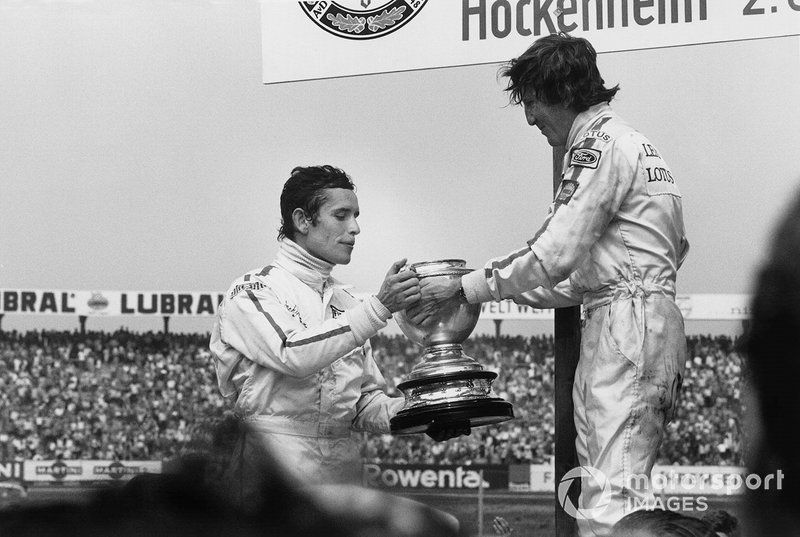 Il vincitore della gara Jochen Rindt, Lotus, da il trofeo pieno di Champagne a Jacky Ickx, Ferrari, secondo classificato, al GP di Germania del 1970