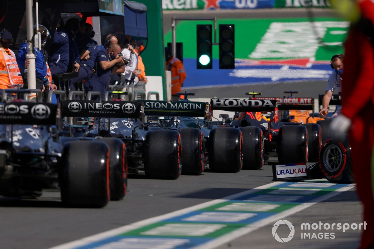 Lance Stroll, Aston Martin AMR21, y Valtteri Bottas, Mercedes W12, en el pit lane