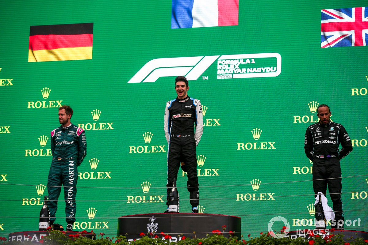 Sebastian Vettel, Aston Martin, secondo classificato, Esteban Ocon, Alpine F1, primo classificato, e Lewis Hamilton, Mercedes, terzo classificato, sul podio
