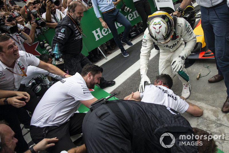 Las barreras se derrumban cuando Lewis Hamilton, Mercedes AMG F1 celebra con su mecánica en el Parc Ferme.