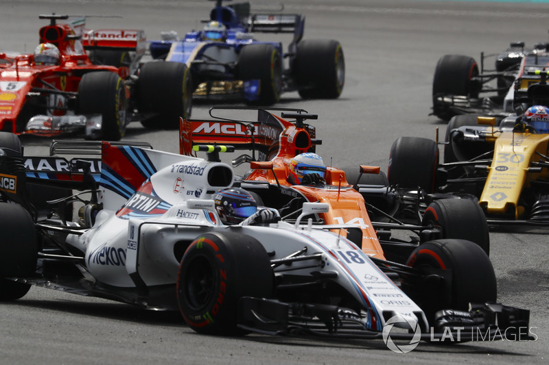 Lance Stroll, Williams FW40, battles Fernando Alonso, McLaren MCL32, Sebastian Vettel, Ferrari SF70H