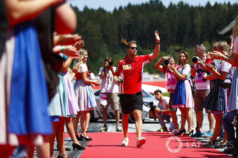 Sebastian Vettel, Ferrari, waves as he passes through lines of grid girls